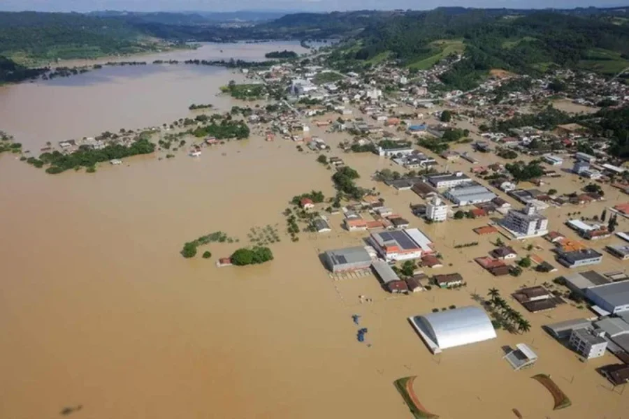 Área urbana alagada em Santa Catarina após chuvas intensas, com ruas, casas e prédios cercados pela água durante enchente