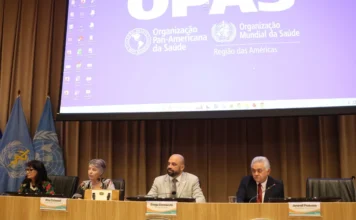 Brasil aprova nova Política de Segurança do Paciente Diogo Demarchi, secretário de Saúde de Santa Catarina, sentado à mesa diretiva durante a assembleia do Conass em Brasília. Ao fundo, um telão exibe as logomarcas da OPAS e OMS. A imagem foca na discussão sobre a Política Nacional de Segurança do Paciente e saúde mental no SUS.