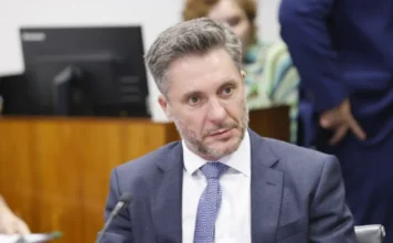 CCJ aprova novo documento para pessoas com deficiência O deputado federal Alex Manente, relator do projeto de Identificação Civil Nacional da Pessoa com Deficiência, em primeiro plano usando terno e gravata durante sessão na CCJ da Câmara dos Deputados.