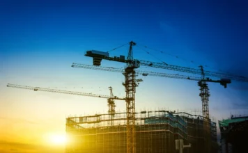 Construção civil em SC deve crescer 1,94% em 2026 Construção civil em Santa Catarina com guindastes e prédio em obra ao pôr do sol