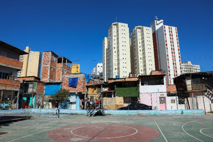 Moradias simples próximas a prédios residenciais em área urbana ilustram desigualdade de renda no Brasil