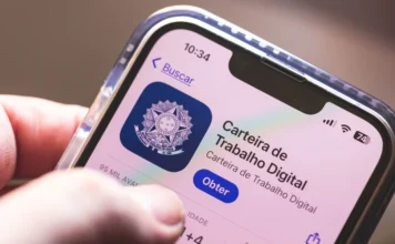 FIESC alerta para impacto da redução da jornada em SC Celular exibe imagem do aplicativo da Carteira de Trabalho Digital em matéria sobre redução da jornada, custos trabalhistas e indústria em SC.