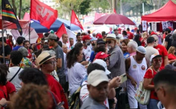 Fim da escala 6×1 marca protestos do 1º de Maio no Brasil Manifestantes reunidos no Eixão do Lazer, em Brasília, durante o ato do Dia do Trabalhador. A imagem mostra uma multidão com bandeiras de centrais sindicais e camisas vermelhas em protesto pelo fim da escala 6x1.