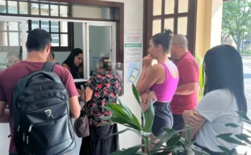 Forquilhinha inicia nova etapa do programa Fila Zero Moradores de Forquilhinha aguardam atendimento em guichê da Secretaria de Saúde para o programa Fila Zero, focado em agilizar consultas e exames especializados. A imagem mostra pessoas em fila na recepção, com cartazes informativos e uma atendente ao fundo, descrevendo o fluxo de serviços públicos para acessibilidade e SEO.