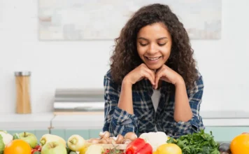 Fortaleça sua imunidade através da alimentação! Mulher observa frutas, legumes e verduras frescas para fortalecer a imunidade por meio da alimentação saudável no inverno