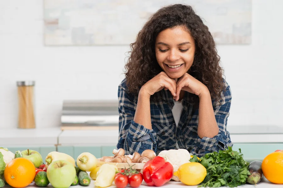 Fortaleça sua imunidade através da alimentação! Mulher observa frutas, legumes e verduras frescas para fortalecer a imunidade por meio da alimentação saudável no inverno