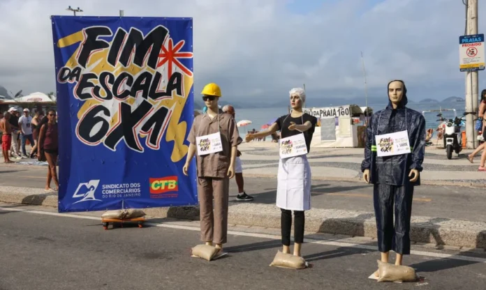 Governo lança campanha pelo fim da escala 6x1 Manifestação no Rio de Janeiro pelo fim da escala 6x1, com faixa do Sindicato dos Comerciários e manequins representando trabalhadores de diferentes setores.