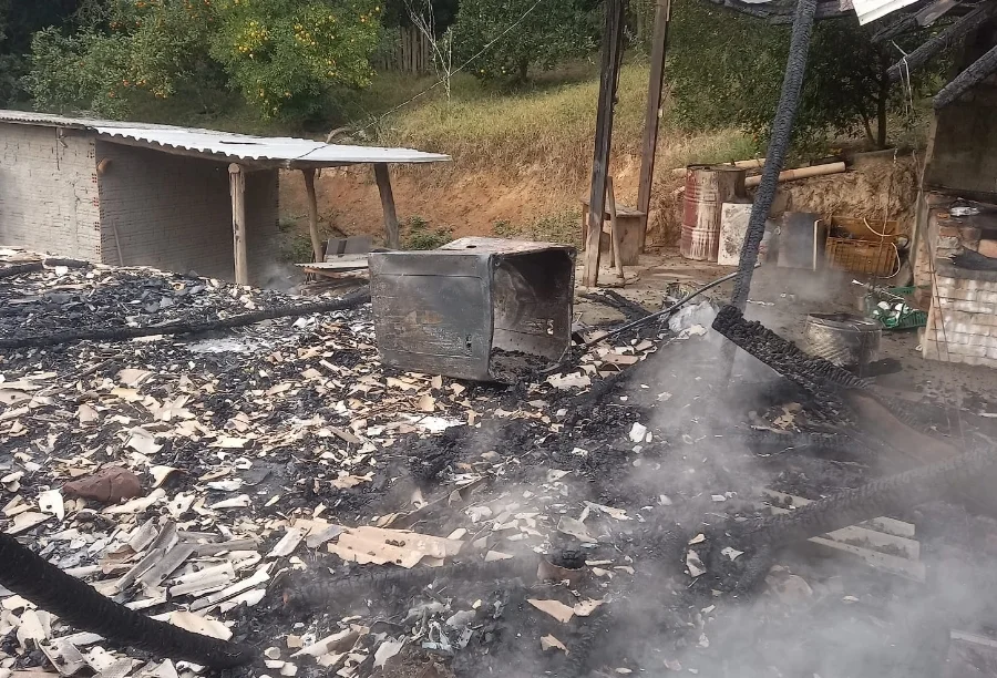 Estrutura destruída por incêndio em casa abandonada no bairro Verdinho, em Criciúma, com escombros, fumaça e área isolada após ação dos bombeiros.