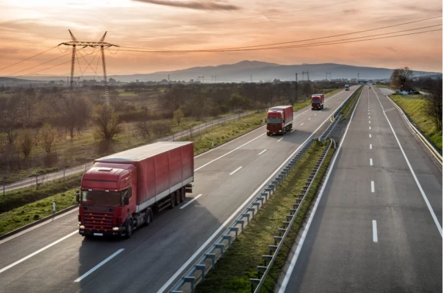 Caminhões trafegam em rodovia durante pôr do sol, ilustrando renovação da frota de transporte rodoviário com crédito de R$ 17 bilhões previsto em medida provisória.
