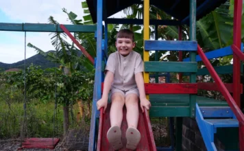 Menino com Síndrome de Dravet inspira lei em SC Davi Guielov da Silva, menino com Síndrome de Dravet que inspirou lei estadual em Santa Catarina, sentado em escorregador em Penha.