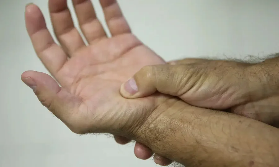 Pessoa segura o próprio punho em imagem relacionada à fibromialgia e ao atendimento de saúde em Morro da Fumaça