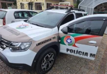 Mulher é presa após esfaquear companheiro no Arroio do Silva Viatura da Polícia Militar de Santa Catarina com a porta dianteira aberta, estacionada em uma rua de paralelepípedos. Imagem ilustrativa representando a mobilização policial para o atendimento de ocorrência de tentativa de homicídio e violência doméstica no Balneário Arroio do Silva.