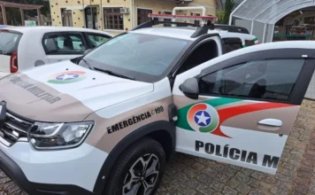 Mulher é presa após esfaquear companheiro no Arroio do Silva Viatura da Polícia Militar de Santa Catarina com a porta dianteira aberta, estacionada em uma rua de paralelepípedos. Imagem ilustrativa representando a mobilização policial para o atendimento de ocorrência de tentativa de homicídio e violência doméstica no Balneário Arroio do Silva.
