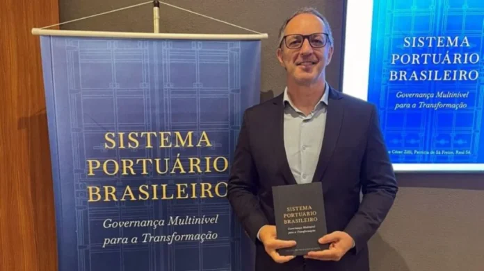 Pesquisa da Unesc vira livro sobre portos no Brasil Professor da Unesc segura livro sobre sistema portuário brasileiro durante lançamento da obra em Santos