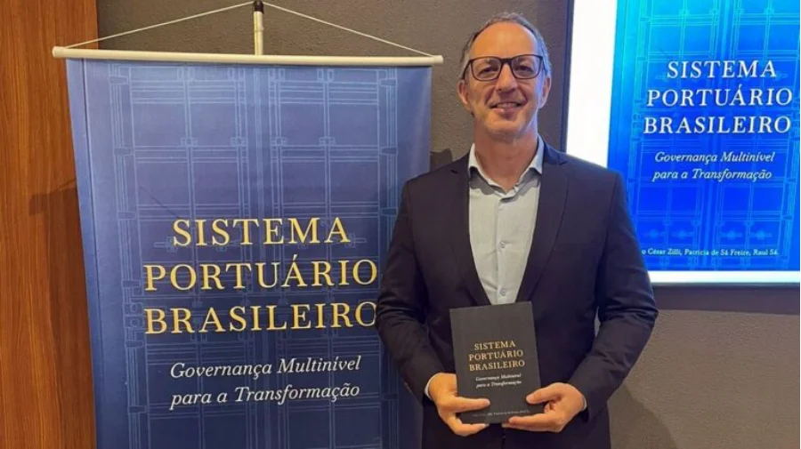 Pesquisa da Unesc vira livro sobre portos no Brasil Professor da Unesc segura livro sobre sistema portuário brasileiro durante lançamento da obra em Santos