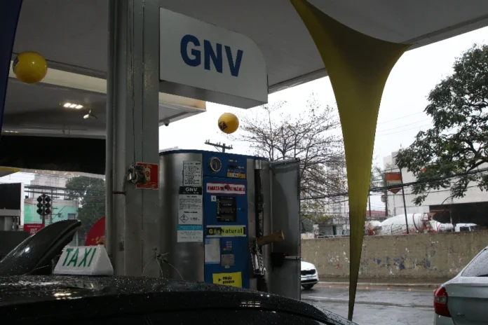 Petrobras sobe preço do gás canalizado em 19,2% Bomba de abastecimento de GNV em posto de combustível com um táxi em destaque. O reajuste de 19,2% da Petrobras no preço do gás canalizado eleva os custos para motoristas que utilizam gás natural veicular.