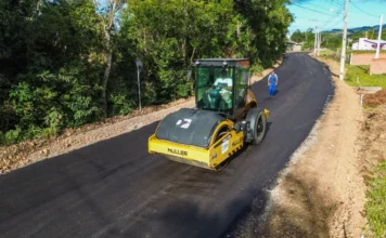 Prefeitura asfalta via em Praia Grande economizando 40% Rolo compressor amarelo Müller operando na aplicação de camada asfáltica na Rua Neri Manoel Maciel, no Bairro Harmonia de Praia Grande, Santa Catarina.