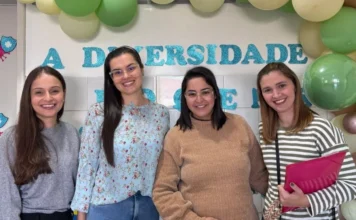 São João do Sul realiza Dia D de saúde para mães atípicas Quatro mulheres sorridentes posam juntas durante o Dia D de saúde para mães atípicas em São João do Sul. Ao fundo, decoração com balões verdes e azuis e parte de um painel sobre diversidade.
