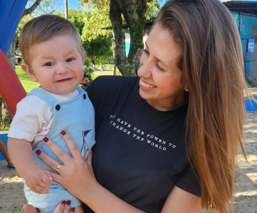 Mãe segura bebê ao ar livre em imagem sobre licença-maternidade estendida de 180 dias na ViaCosteira