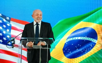 Viagens do governo federal somam R$ 2,5 bi em 2025 Presidente em evento oficial com bandeiras do Brasil e dos Estados Unidos ao fundo, em matéria sobre gastos com viagens do governo federal em 2025.