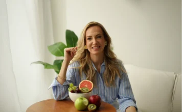 Comer saudável sem gastar muito: é possível, sim! Nutricionista com frutas frescas em ambiente claro, representando alimentação saudável, acessível e equilibrada no dia a dia.