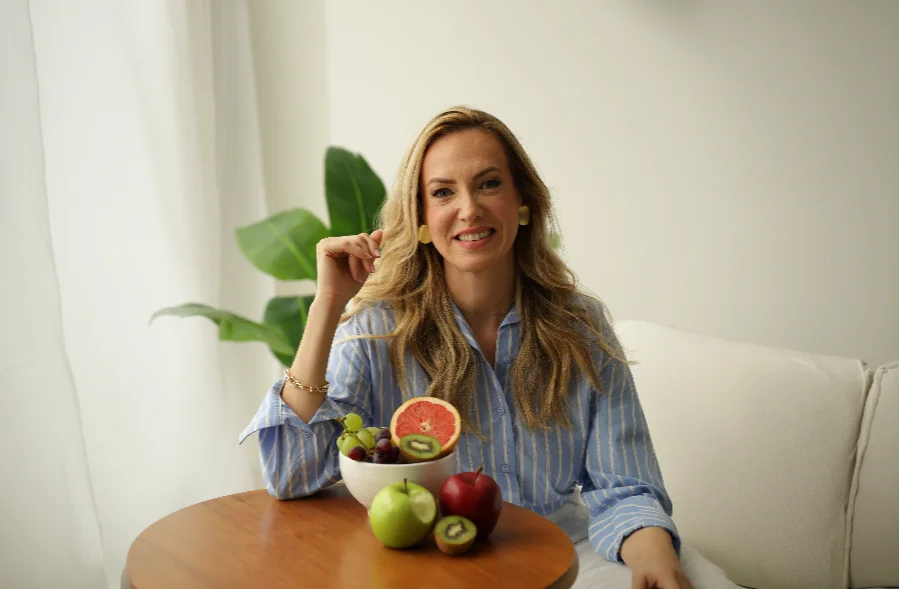 Comer saudável sem gastar muito é possível, sim Nutricionista com frutas frescas em ambiente claro, representando alimentação saudável, acessível e equilibrada no dia a dia.