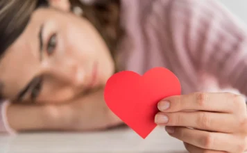 Dia dos Namorados acende alerta emocional em solteiros Mulher segurando coração vermelho em imagem ilustrativa sobre Dia dos Namorados, solteiros e saúde emocional
