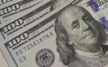 Dólar chega ao maior valor em dois meses após dados dos EUA Notas de 100 dólares aparecem em destaque em imagem sobre alta do dólar e mercado financeiro dos Estados Unidos