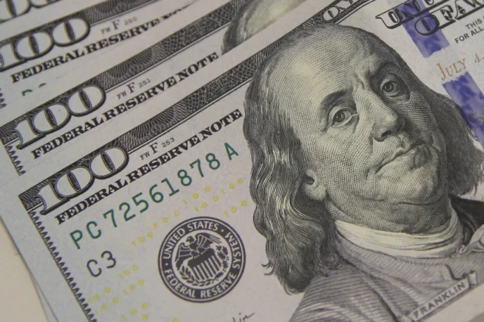 Dólar chega ao maior valor em dois meses após dados dos EUA Notas de 100 dólares aparecem em destaque em imagem sobre alta do dólar e mercado financeiro dos Estados Unidos