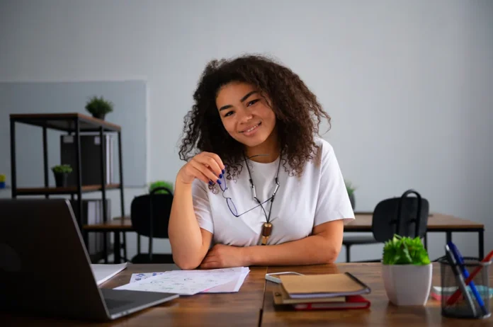 Jovens lideram pedidos de demissão no mercado formal Jovem profissional em ambiente de trabalho com notebook e documentos, representando geração Z, job hopping e mudanças no mercado de trabalho.