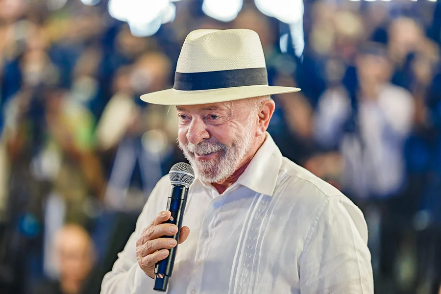 Presidente Luiz Inácio Lula da Silva segura microfone durante evento público; imagem relacionada ao arquivamento de inquérito pelo MPF sobre comentário em rede social.