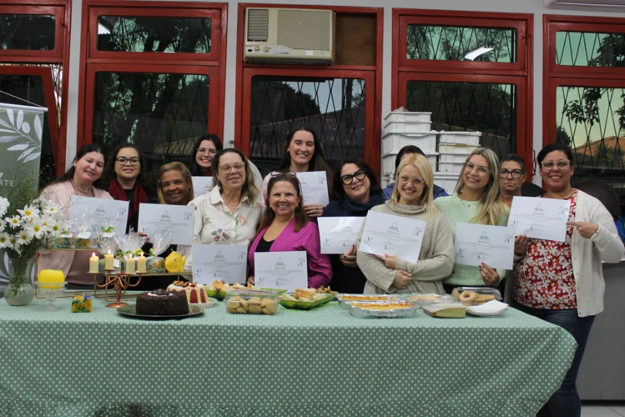 Oficina de velas da Unesc forma nova turma em Criciúma Participantes da Oficina de Velas Artesanais da Unesc exibem certificados durante encerramento de turma em Criciúma, com velas e produtos artesanais sobre a mesa.