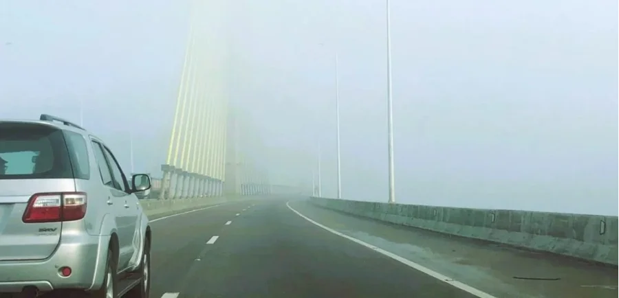 Veículo trafega em trecho de rodovia com neblina intensa na BR-101 Sul/SC, em alerta da ViaCosteira sobre segurança viária e baixa visibilidade.