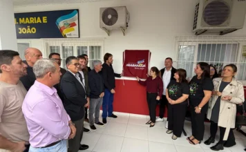 Araranguá reinaugura o CEI Maria e João na Urussanguinha Prefeito, autoridades e comunidade reunidos em frente à fachada do CEI Maria e João durante descerramento da placa de reinauguração em Araranguá.