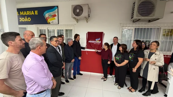 Araranguá reinaugura CEI ampliado na Urussanguinha Prefeito, autoridades e comunidade reunidos em frente à fachada do CEI Maria e João durante descerramento da placa de reinauguração em Araranguá.