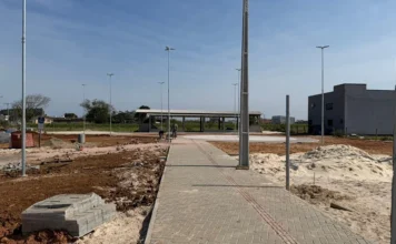 Araranguá terá nova praça de 3 mil m² no Caverazinho Obras de construção da nova praça pública no bairro Caverazinho, em Araranguá, com calçamento e postes de iluminação sendo instalados.