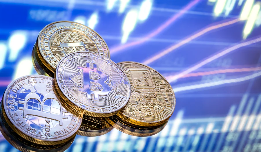 Moedas representando Bitcoin e outras criptomoedas diante de gráfico financeiro, em referência às novas regras do Banco Central para transferências de criptoativos.