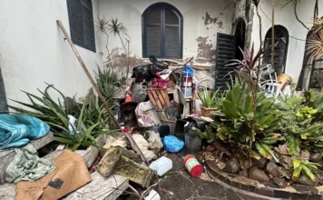 Criciúma limpa casa com resíduos até perto do teto Área externa de residência no Centro de Criciúma com grande acúmulo de resíduos, móveis e materiais inservíveis durante intervenção da Prefeitura.