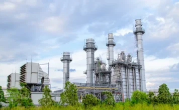 FIESC cria plataforma para mapear emissões da indústria Unidade industrial com torres e estruturas de produção, ilustrando o mapeamento de emissões da indústria pela FIESC.