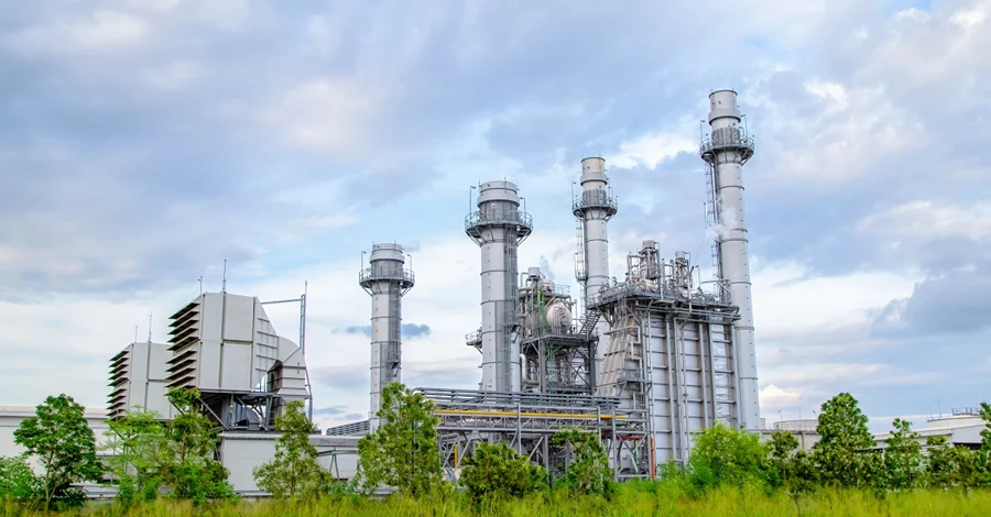 FIESC cria plataforma para mapear emissões da indústria Unidade industrial com torres e estruturas de produção, ilustrando o mapeamento de emissões da indústria pela FIESC.