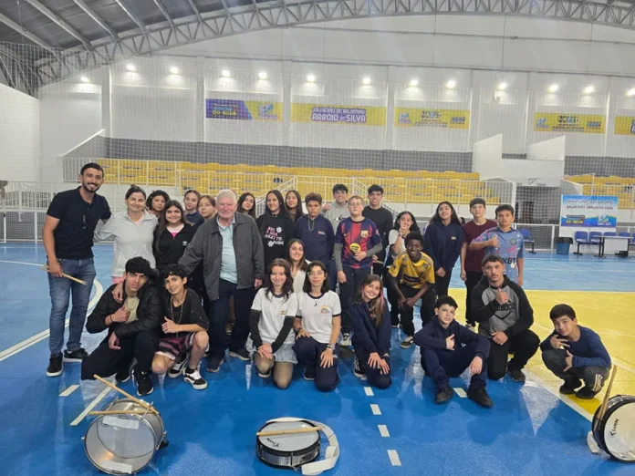 Fanfarra intensifica ensaios para desfile em Arroio do Silva Integrantes da fanfarra de Balneário Arroio do Silva reunidos durante ensaio para o desfile cívico, com instrumentos de percussão no ginásio municipal.