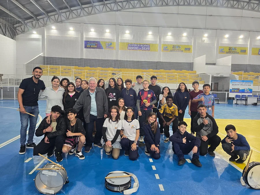Fanfarra intensifica ensaios para desfile em Arroio do Silva Integrantes da fanfarra de Balneário Arroio do Silva reunidos durante ensaio para o desfile cívico, com instrumentos de percussão no ginásio municipal.