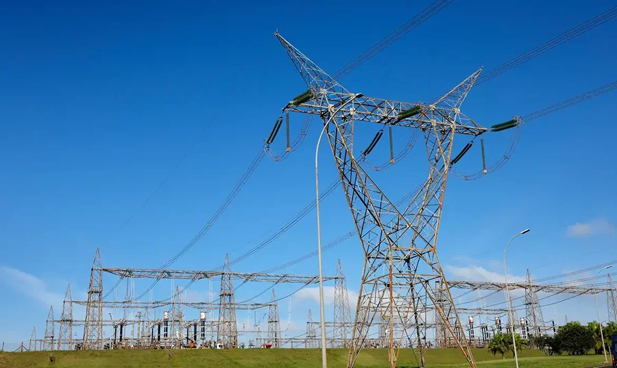 Torre e linhas de transmissão de energia elétrica, tema do mercado livre de energia para consumidores no Brasil.