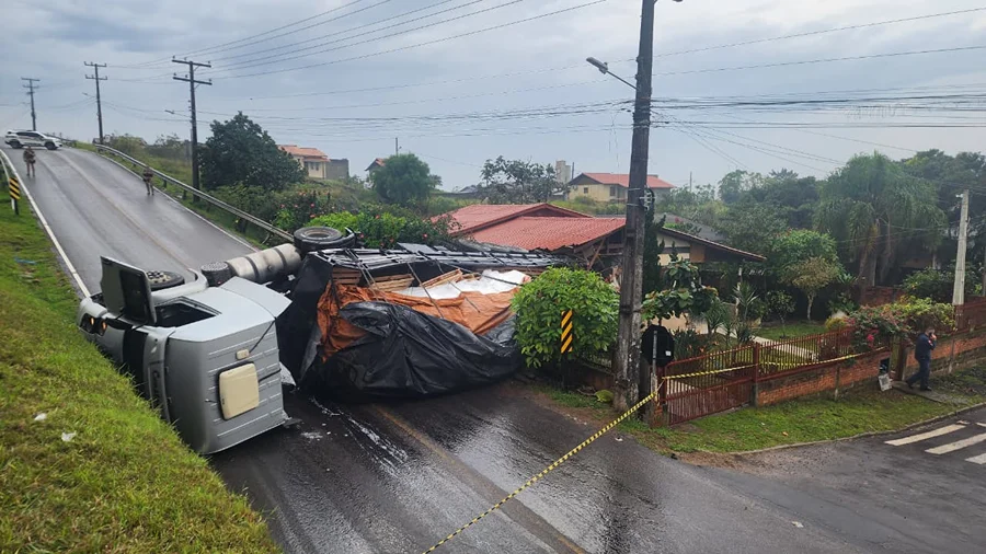 Caminhão carregado com polietileno tombado após atingir residência na Rua Quintiliano Raupp, no bairro Raizeira, em Sombrio.