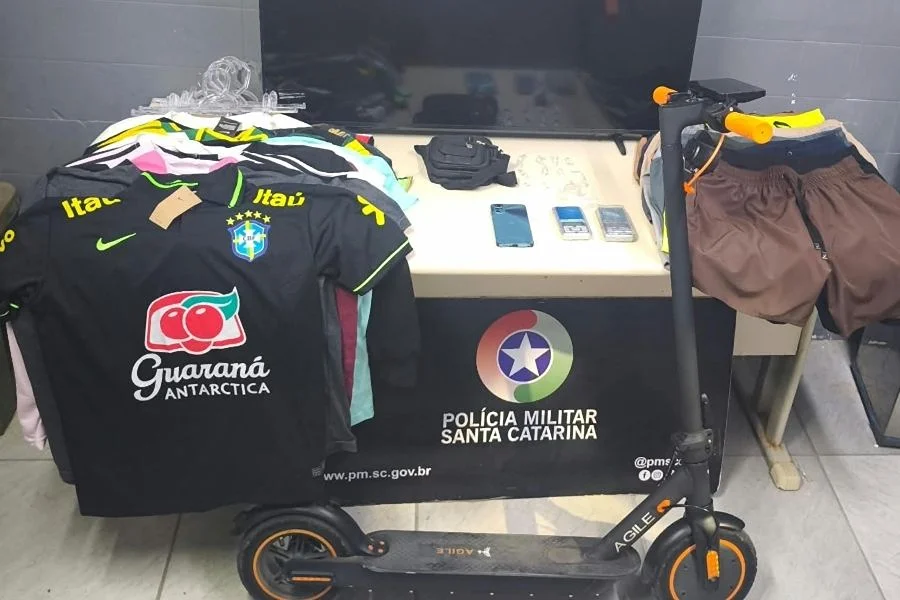 PM apreende crack e recupera itens furtados em Criciúma Objetos apreendidos pela Polícia Militar em ocorrência de tráfico de drogas e receptação no bairro Mina União, em Criciúma, incluindo roupas, celulares, televisão e patinete elétrico.