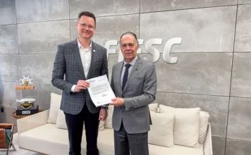 SC libera R$ 186 milhões a exportadoras afetadas Representantes da FIESC seguram documento sobre medidas de apoio às exportadoras catarinenses afetadas pelo tarifaço dos Estados Unidos.