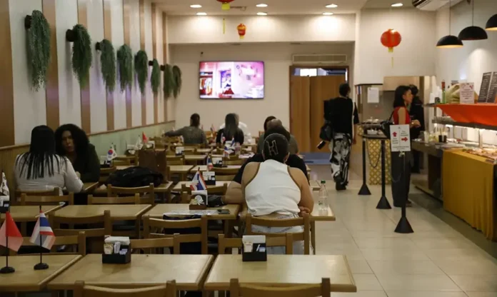 Serviços empregaram 15,9 milhões no Brasil em 2024 Restaurante com clientes em mesas e funcionários no atendimento, atividade de alimentação que liderou os empregos no setor de serviços não financeiros em 2024.
