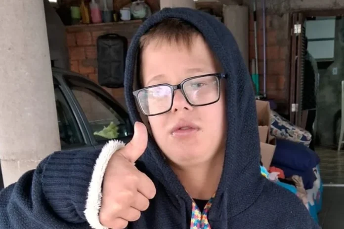 Sombrio terá brechó em apoio a menino com autismo Erick Rodrigues Sebastião, de 10 anos, aparece usando óculos e fazendo sinal de positivo em Sombrio.
