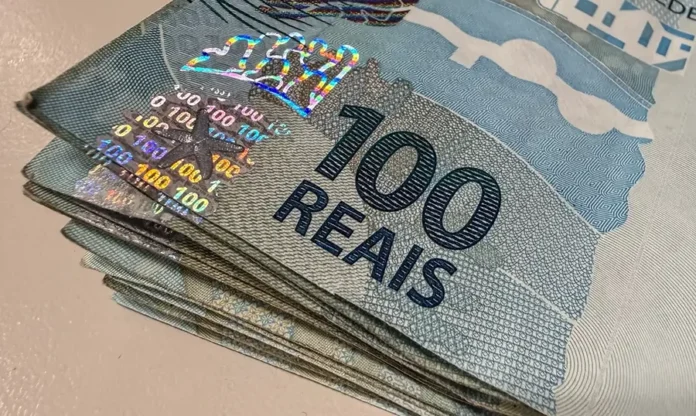 Tesouro eleva fatia da dívida atrelada à Selic em 2026 Cédulas de R$ 100 empilhadas ilustram Dívida Pública Federal, Tesouro Nacional e títulos atrelados à Taxa Selic.