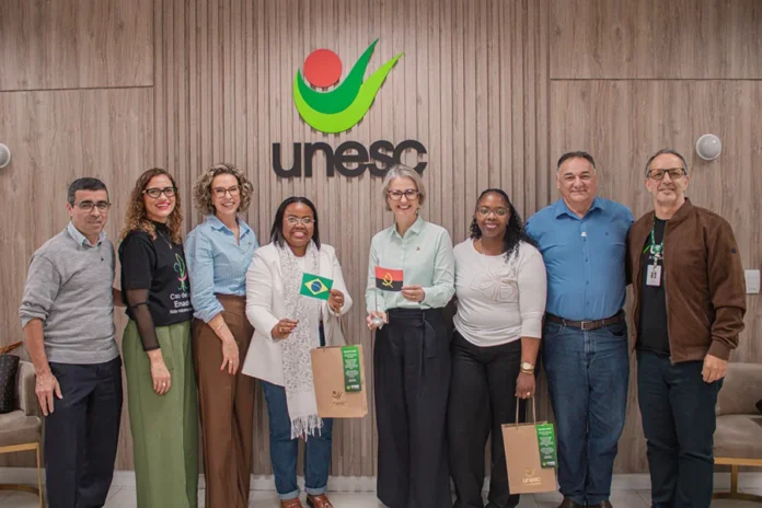 Unesc e instituição de Angola discutem acordo acadêmico Representantes da Unesc e do Instituto Superior Privado do Wako Kungo, de Angola, durante encontro de cooperação acadêmica em Criciúma, com as bandeiras do Brasil e de Angola.